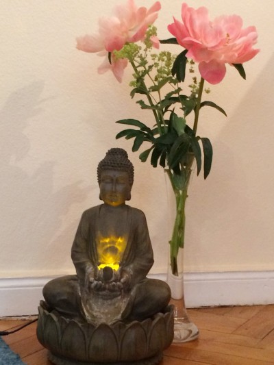Beleuchteter Buddha mit 2 rosa Pfingstrosen