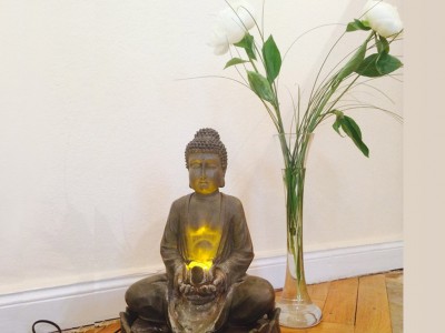Buddha mit zwei weissen Rosen